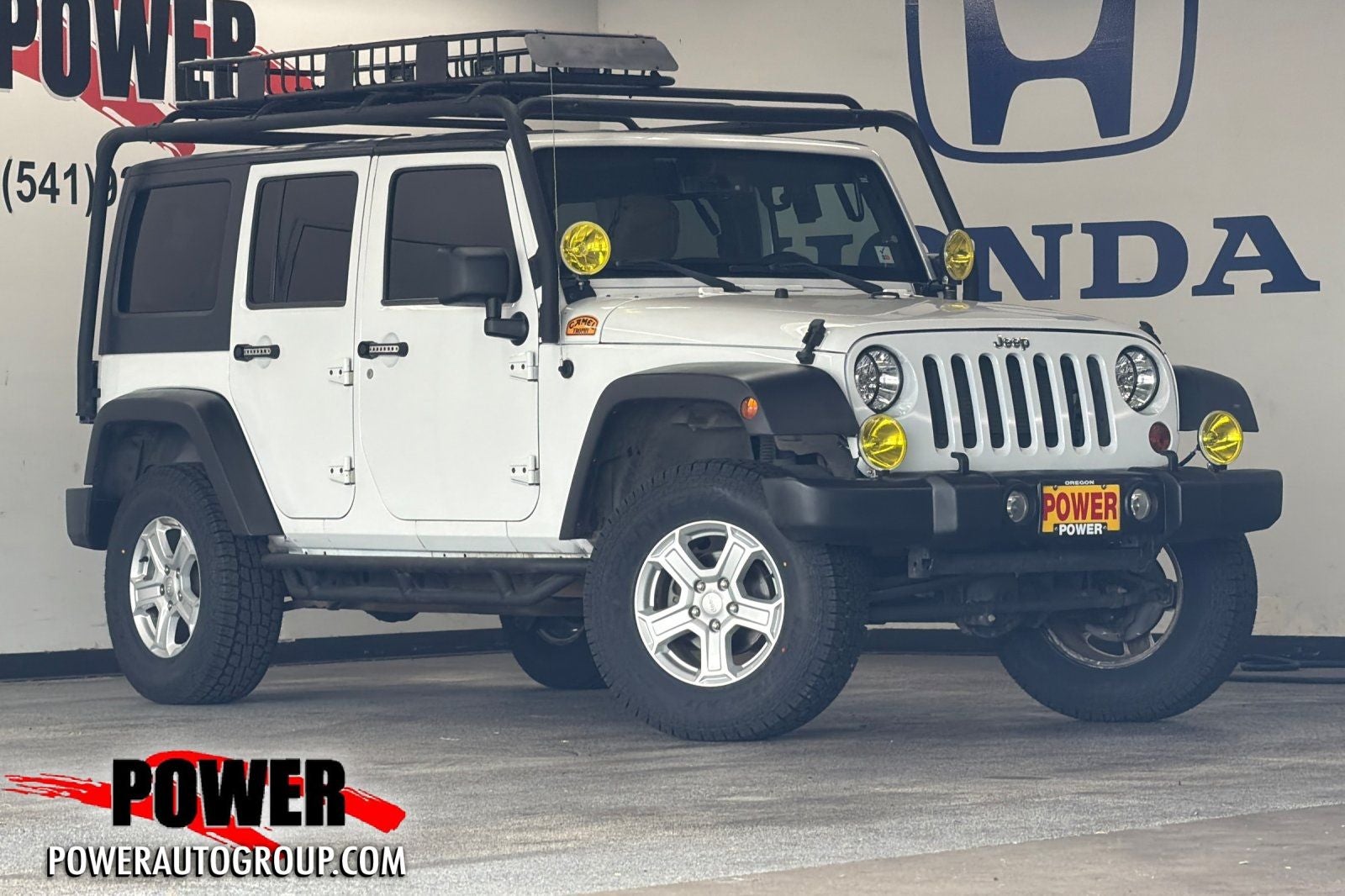 2013 Jeep Wrangler Unlimited Sport in Bright White — front three-quarter view